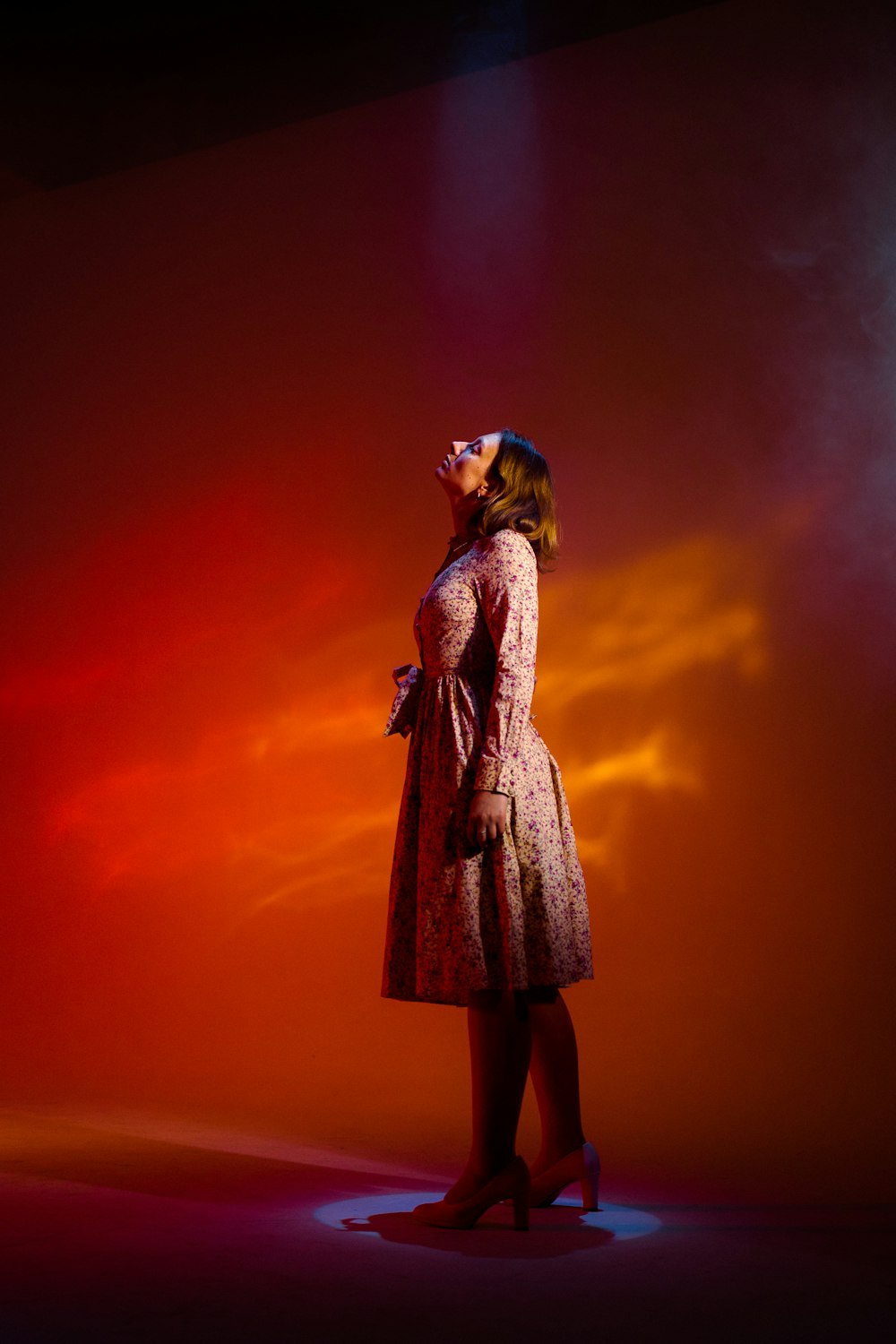 a woman in a pink dress is standing in front of a red background