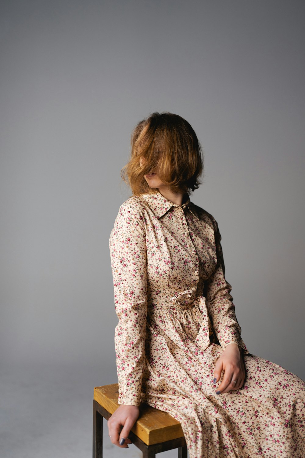 a woman sitting on top of a wooden stool