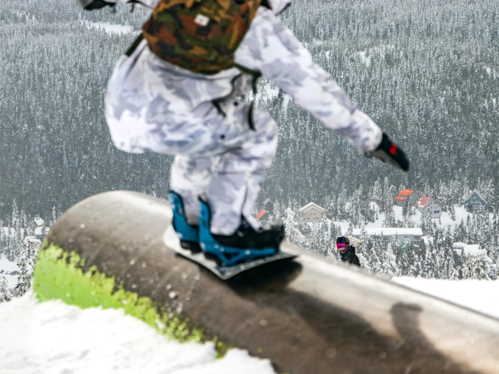 a man riding a snowboard down the side of a metal rail