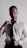 Close-up of a sharply dressed man adjusting his tie in a sleek, modern setting.