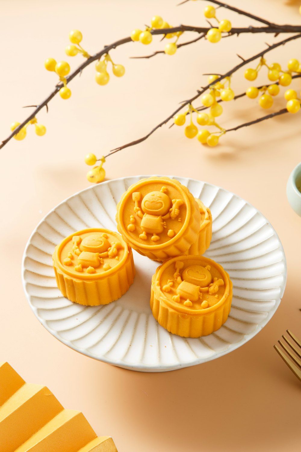 a white plate topped with three yellow mooncakes