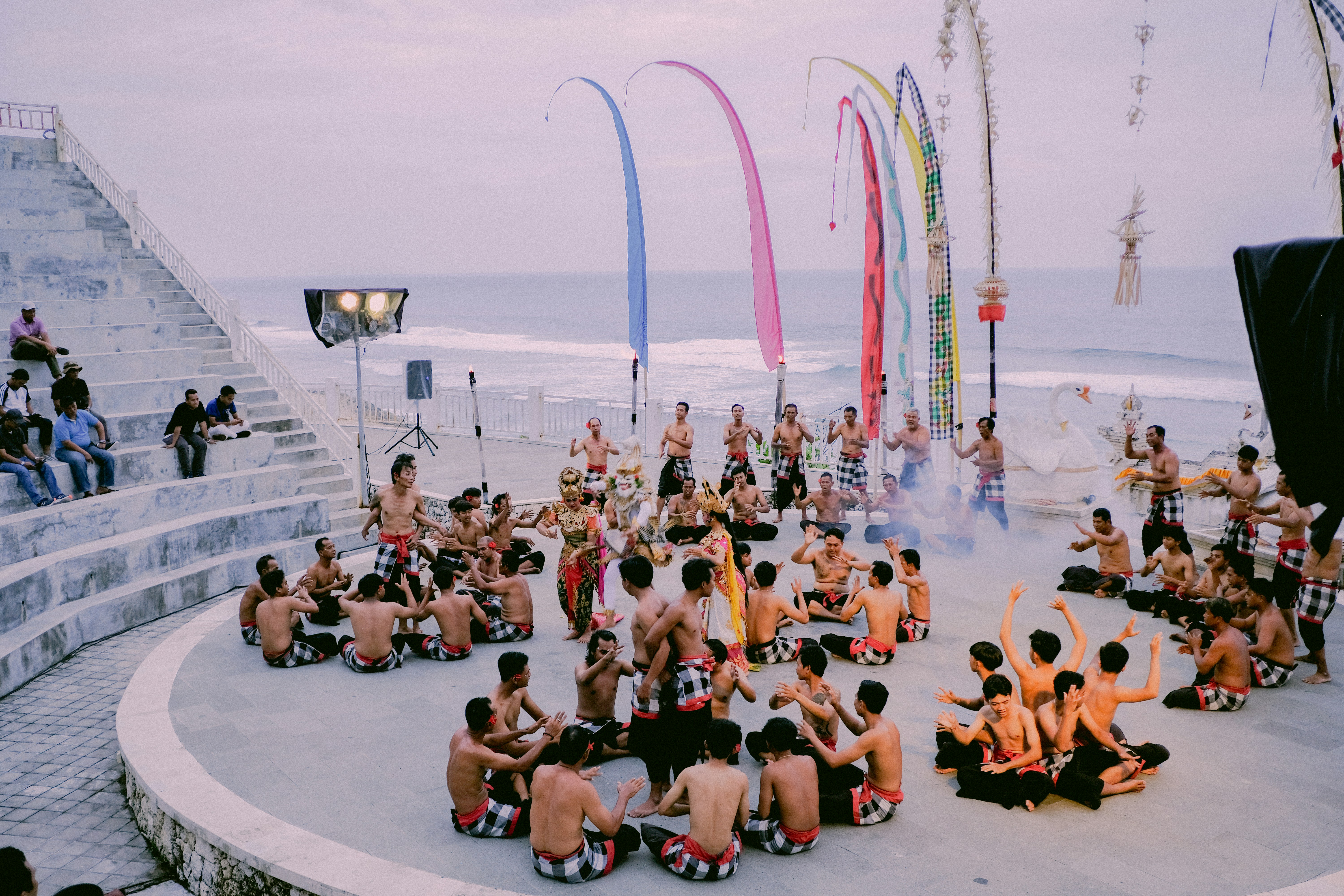 a group of people sitting on top of a cement platform