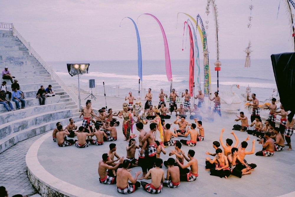 a group of people sitting on top of a cement platform