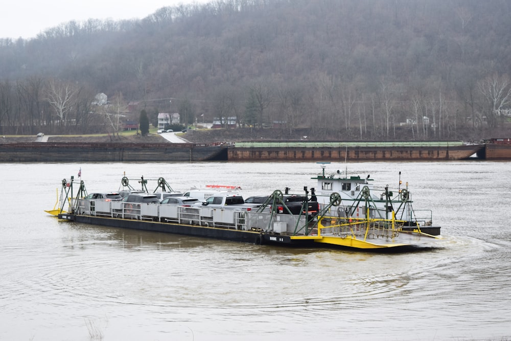 a large boat traveling down a river next to a forest