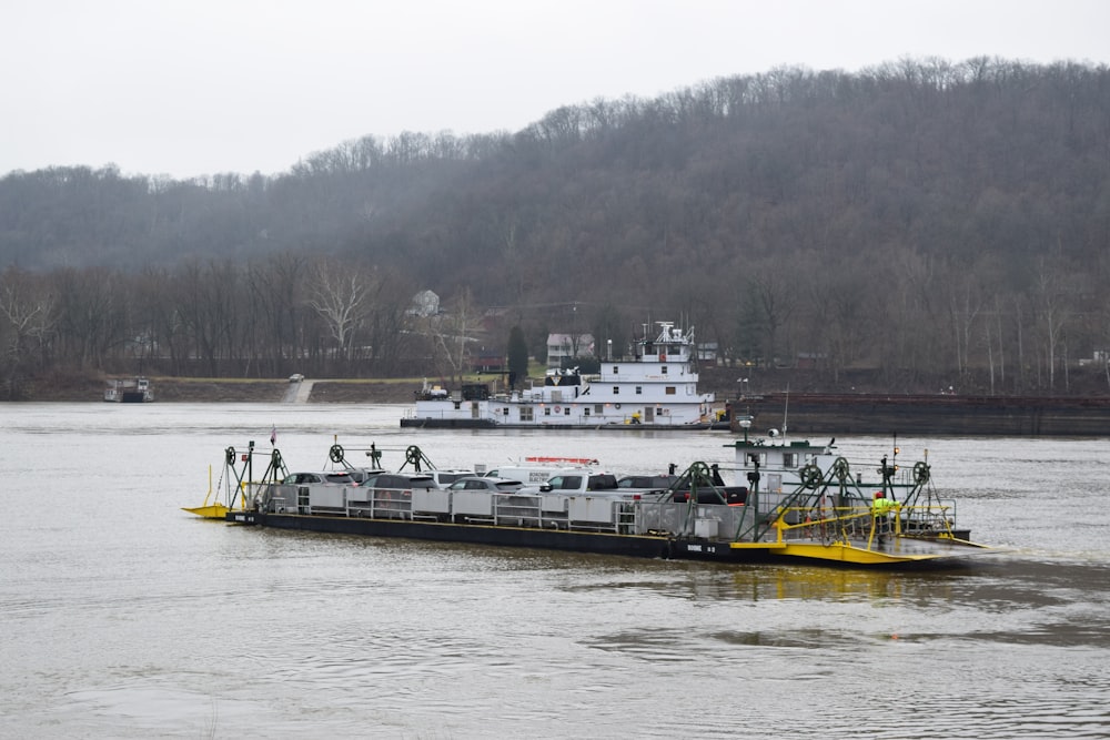 a large boat floating on top of a river next to a forest