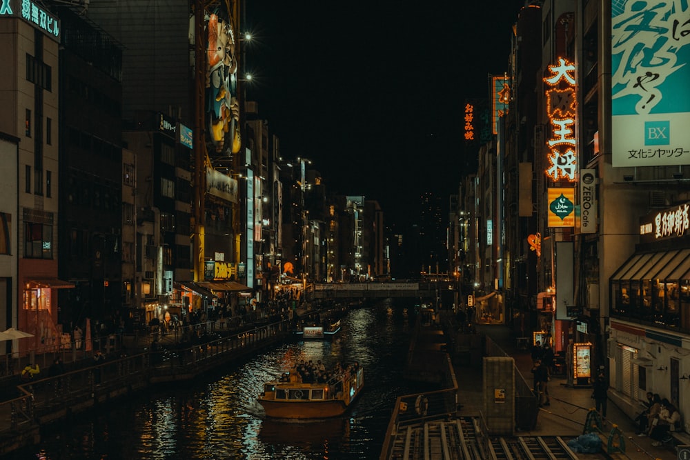 a boat floating down a river next to tall buildings