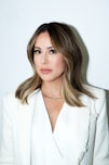 a woman in a white jacket posing for a picture