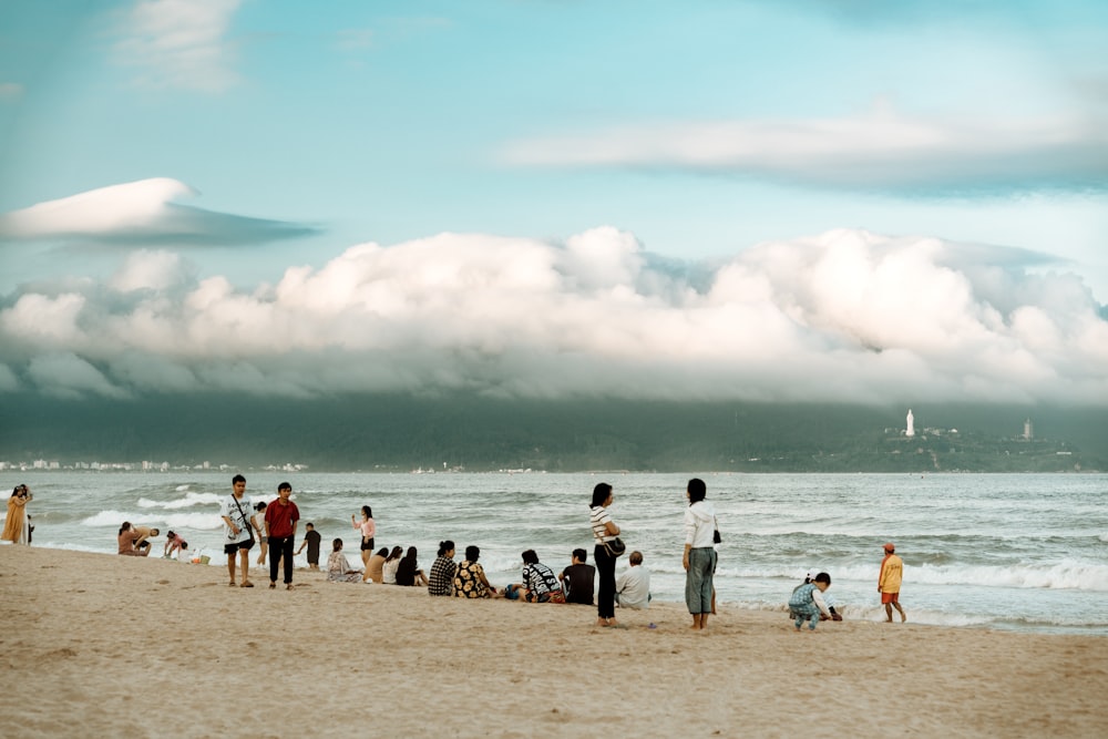 a group of people standing on top of a sandy beach