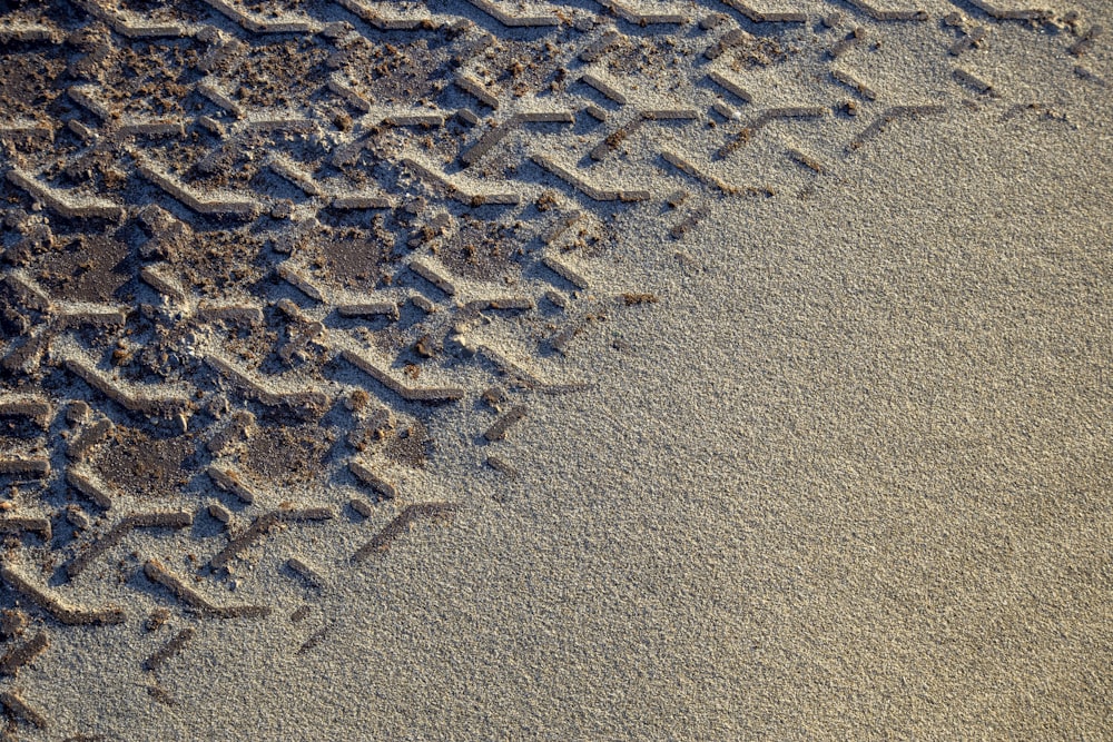 a close up of a tire track in the sand