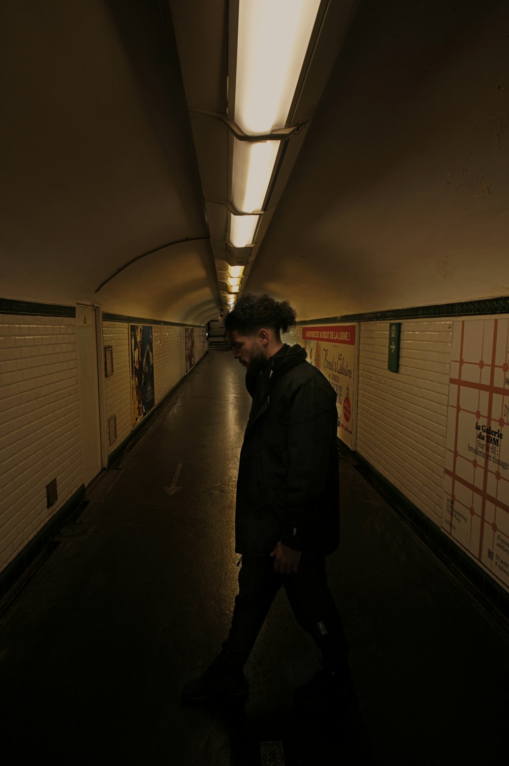 a man is walking down a long hallway