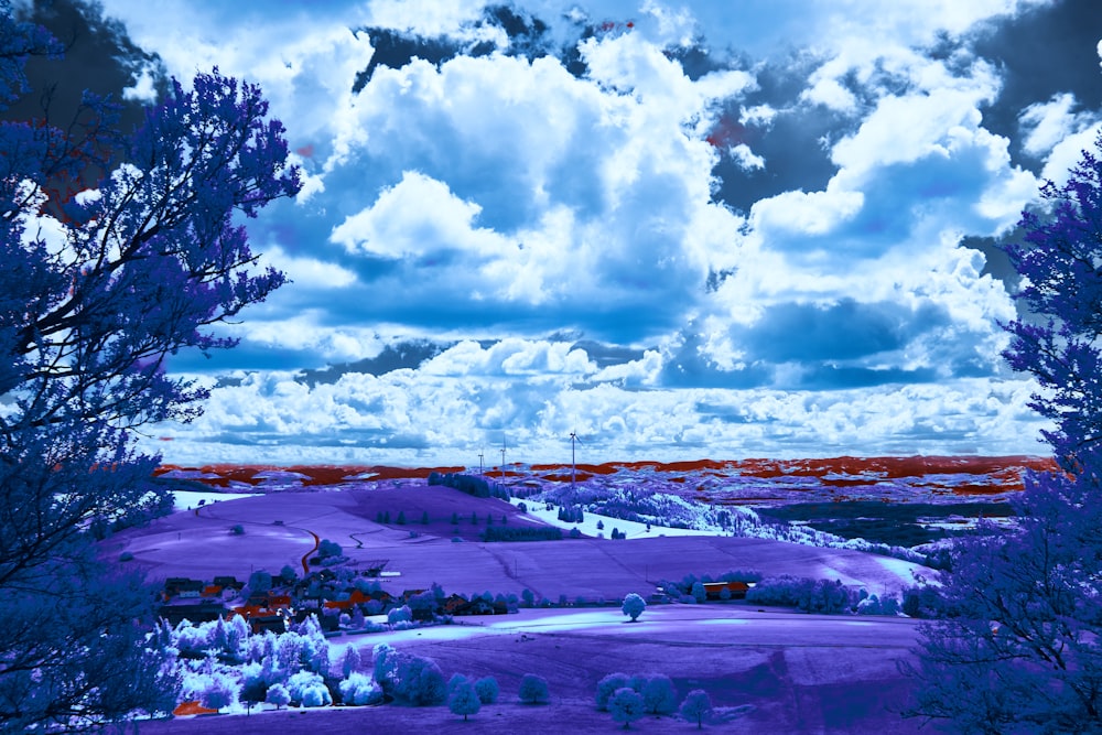 a purple landscape with trees and clouds in the background