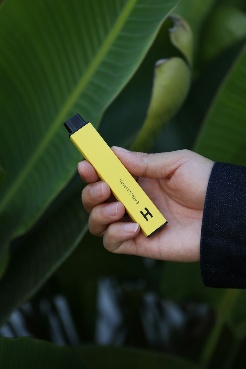 a person holding a yellow electronic device in their hand