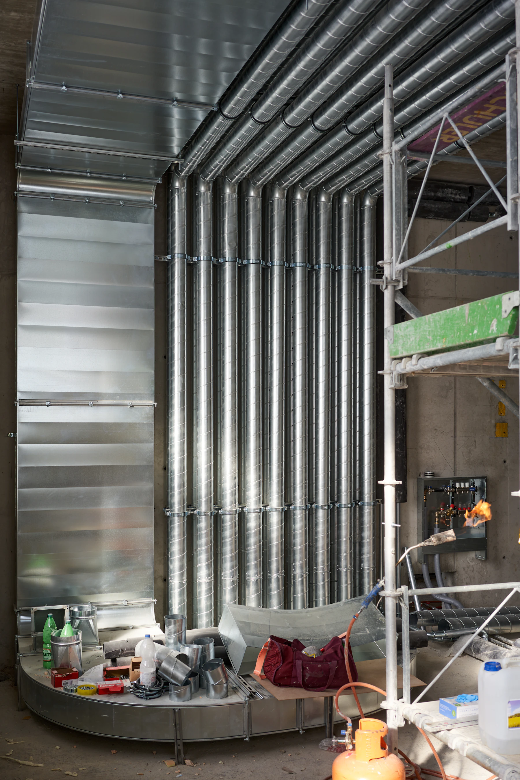 A wall of professionally installed round sheet-metal ductwork in a mechanical space