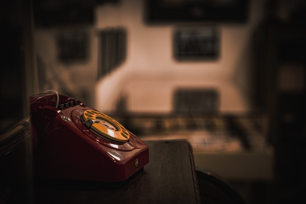 a red phone sitting on top of a wooden table