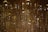 A close-up view of a shimmering crystal chandelier with numerous faceted prisms reflecting light and creating a warm, golden glow. The intricate detail of the crystals creates a luxurious and opulent effect.