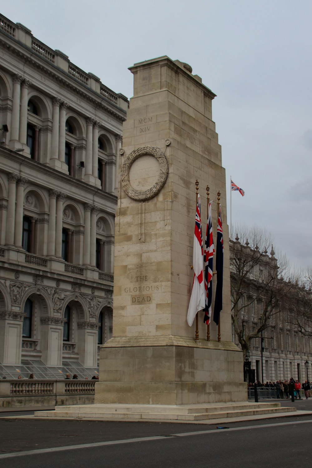 a monument with two flags on it in front of a building