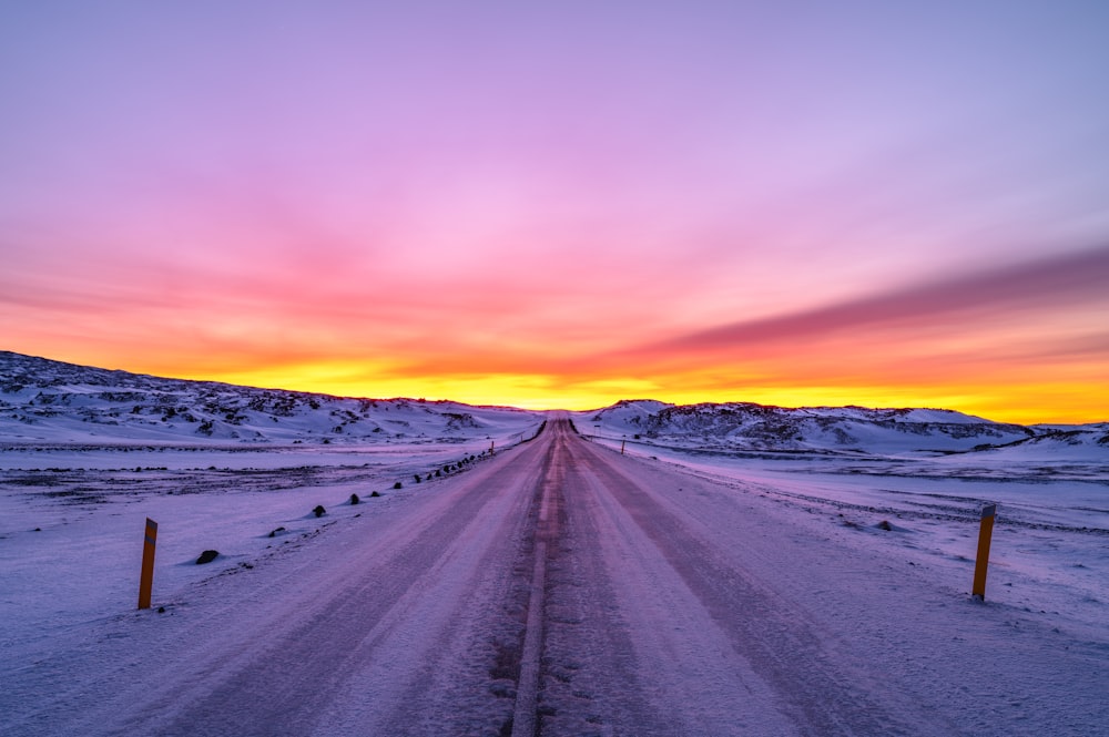 a road in the middle of a snowy field