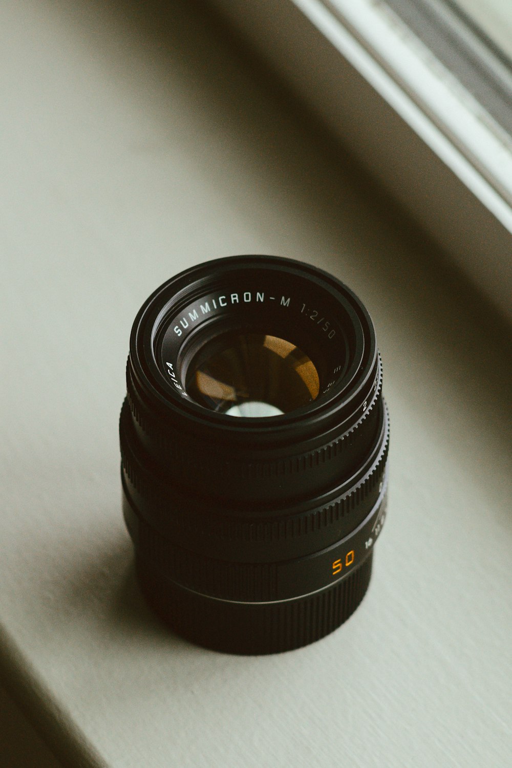 a camera lens sitting on top of a window sill