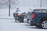 a woman standing on top of a truck in the snow