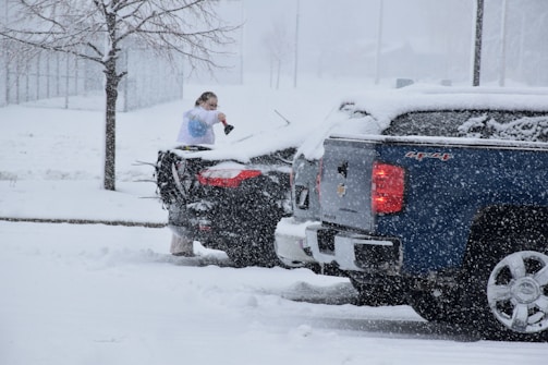 a woman standing on top of a truck in the snow