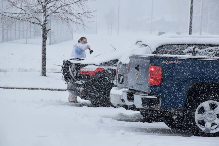 a woman standing on top of a truck in the snow