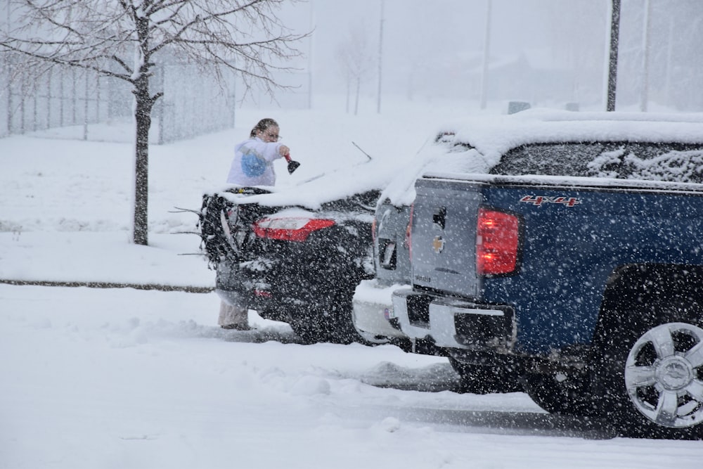 Una mujer parada encima de un camión en la nieve