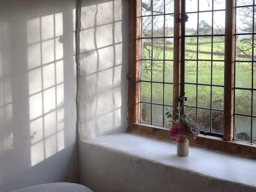 a vase with flowers sitting on a window sill