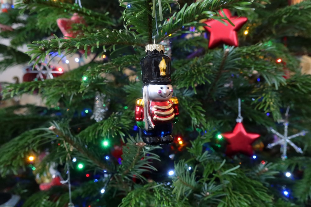 a nutcracker ornament hanging from a christmas tree