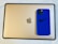 A blue smartphone case with a Nike logo and the phrase 'Just Do It' sits on top of a gold-colored tablet with an Apple logo.