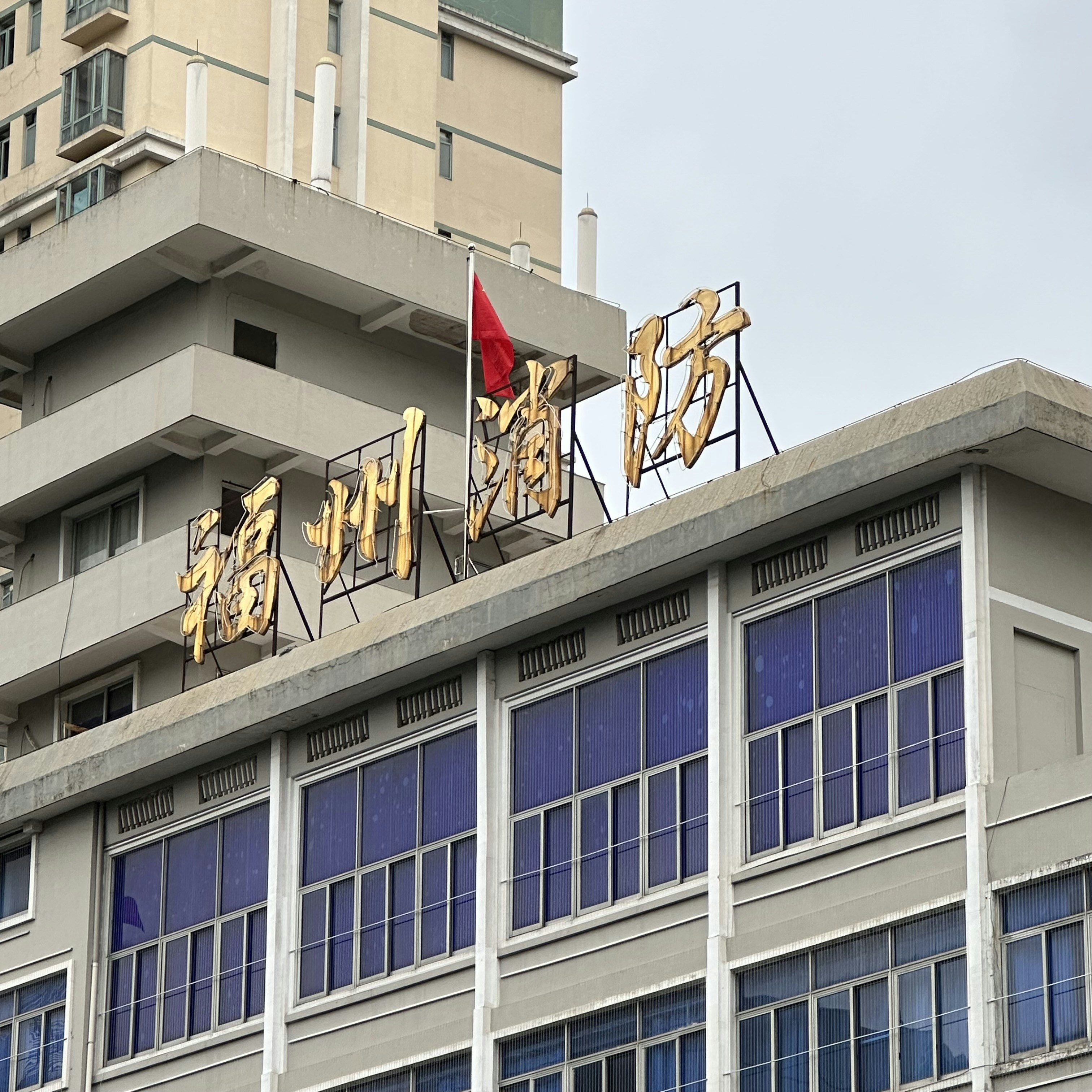 a tall building with a red flag on top of it