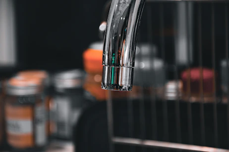 Close-up of a newly installed bathroom faucet shining under soft lighting.