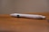 A white pen with 'BMI Healthcare' printed on it rests on a wooden surface. The background is blurred, highlighting the pen as the focal point.