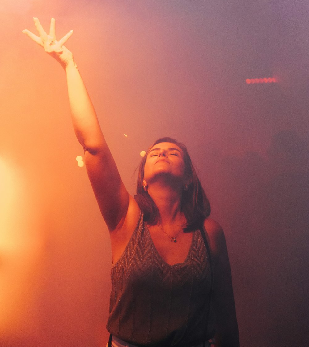 a woman holding her hand up in the air