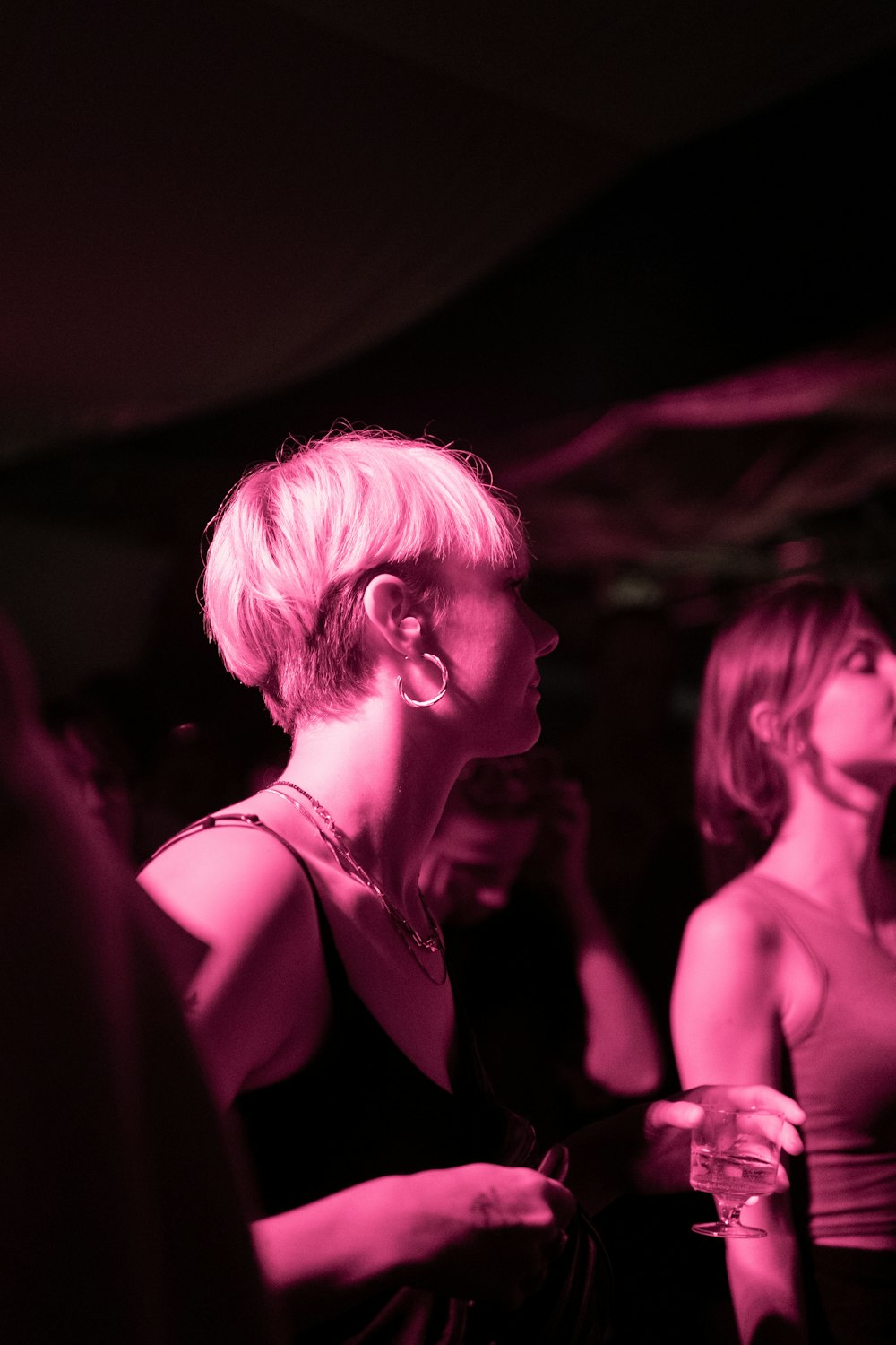 a woman in a black dress standing in a dark room