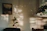 A cozy living room wall adorned with a vibrant Chris Antrim painting, sunlight streaming in.