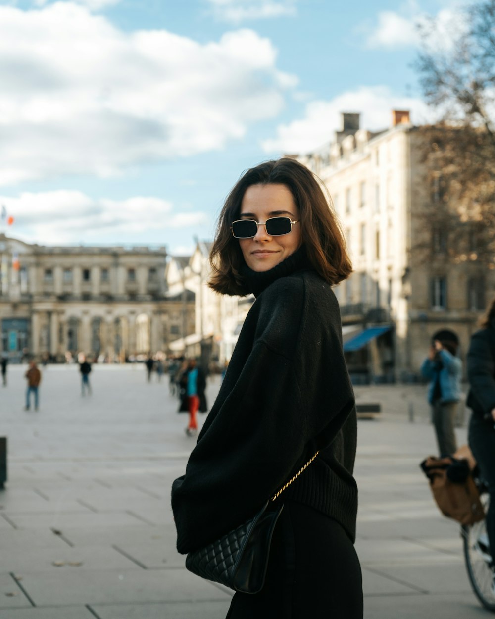 a woman wearing sunglasses and a black coat