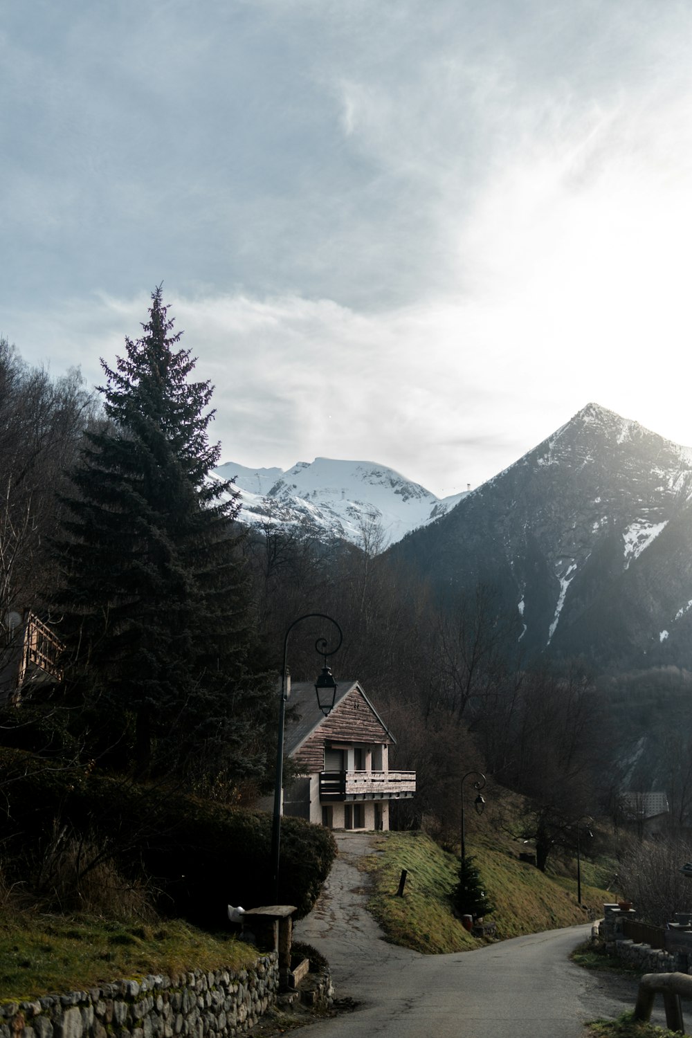 a house on the side of a road with a mountain in the background