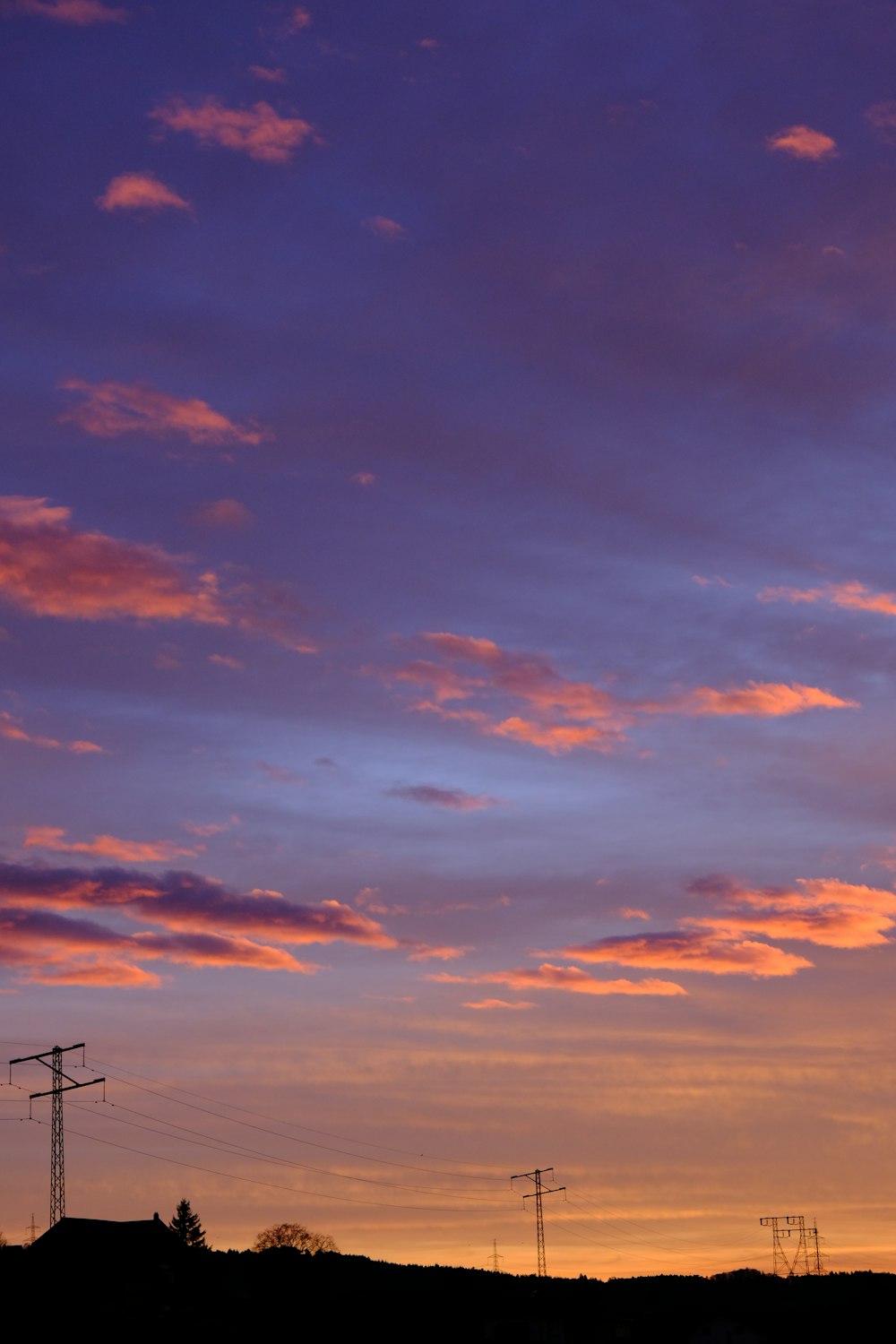 a view of a sunset with power lines in the foreground