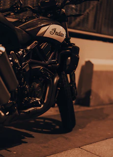 A sleek, rare Indian motorcycle gleaming under neon streetlights at night.