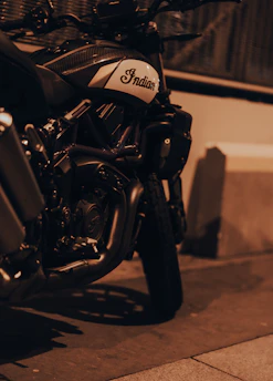 A sleek, rare Indian motorcycle gleaming under neon streetlights at night.