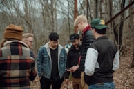Team members discussing findings around a field laptop in a forested area.