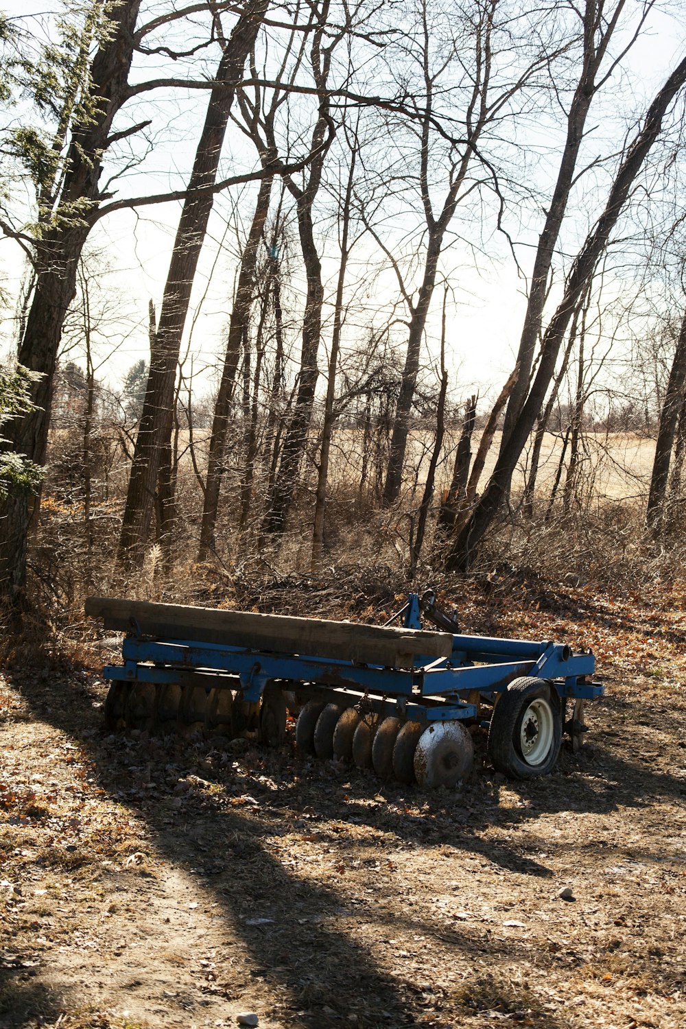 a plow is parked in the middle of a wooded area