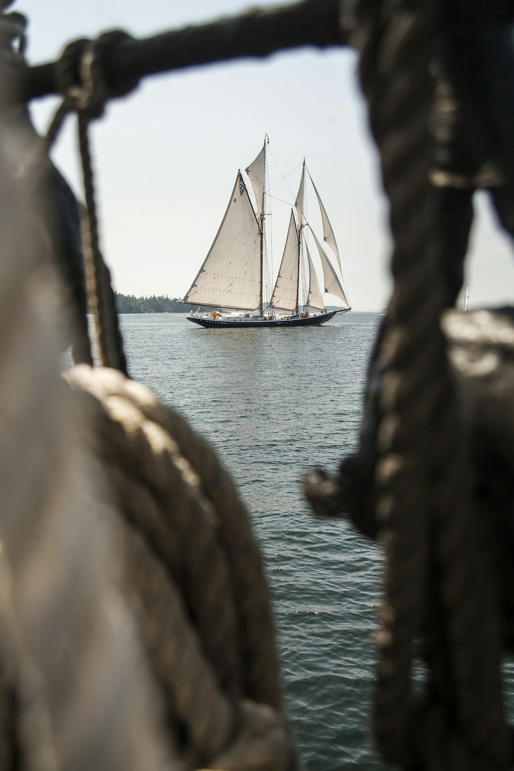 a sailboat sailing in the ocean on a sunny day