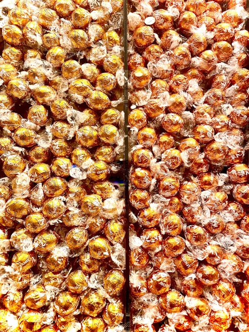 Rows of chocolate bars wrapped in shiny foil stacked on shelves