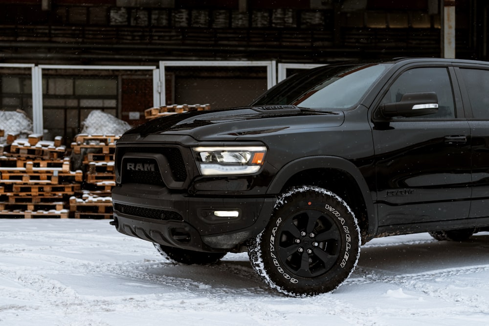 a black ram truck is parked in the snow
