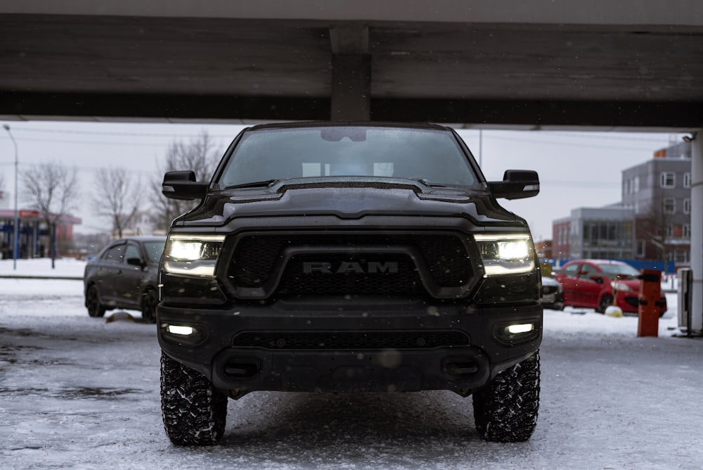 a black ram truck parked under a bridge