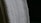 A close-up view of a white textured fabric with intricate woven patterns, displayed against a dark background. The fabric edges appear detailed and the weave texture is clearly visible, emphasizing its tactile quality.