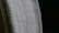 A close-up view of a white textured fabric with intricate woven patterns, displayed against a dark background. The fabric edges appear detailed and the weave texture is clearly visible, emphasizing its tactile quality.