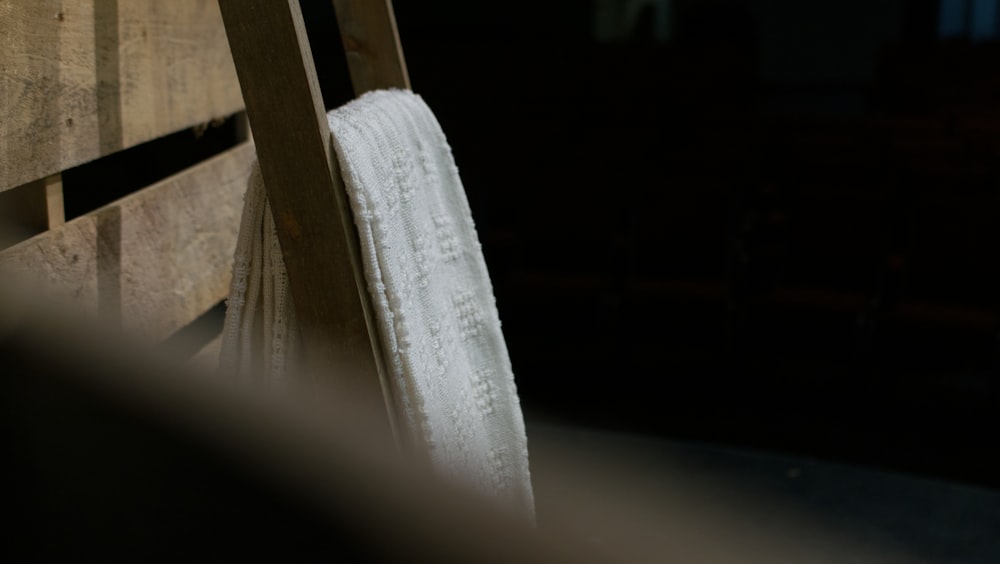 a wooden bench with a white towel hanging from it