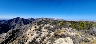 A stunning panoramic view of the puna landscape surrounding Lagunillas del Farallon, with mountains under a clear blue sky.